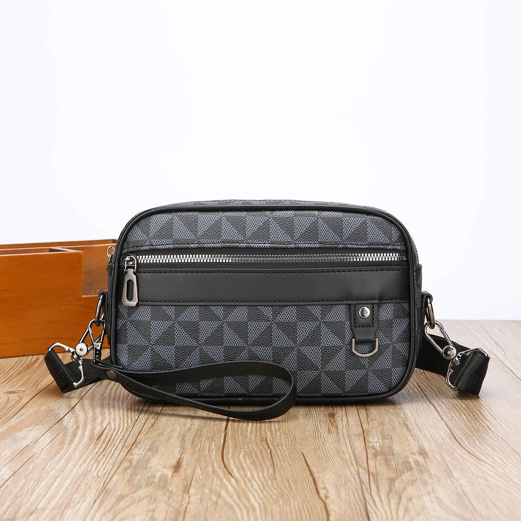 Men's black PU leather messenger bag with a geometric pattern, shown worn crossbody.