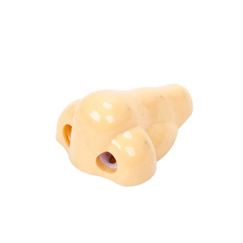 Flesh-colour plastic manual pencil sharpener with a large nostril and geometry-shaped body.