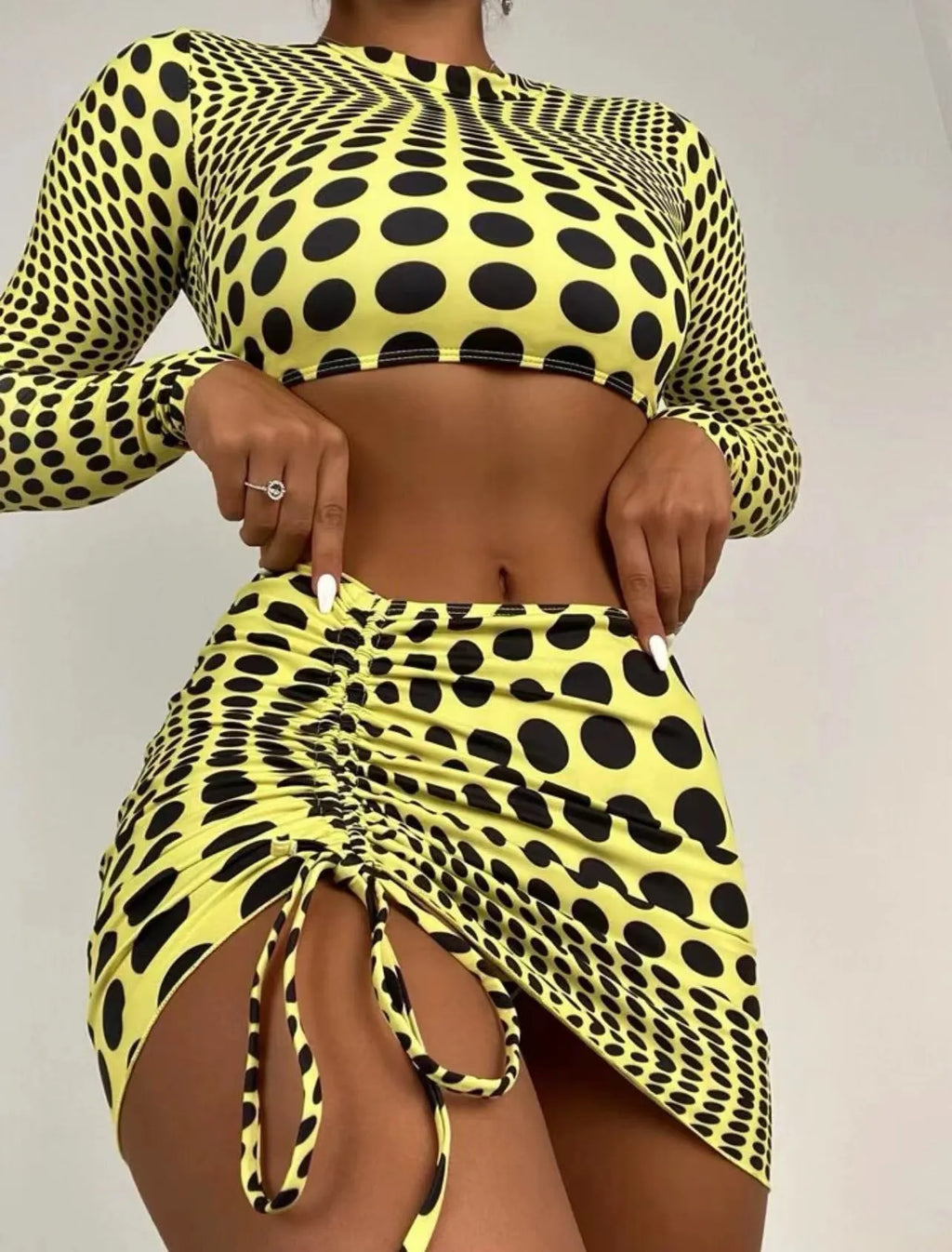 Green and yellow polka dot women's swimsuit three-piece set showing top, skirt, and bra