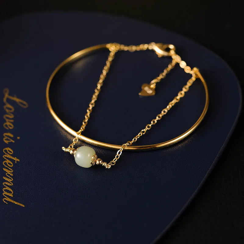 Hetian jade bracelet with gold inlay in single, double, and three bead versions on a wrist.