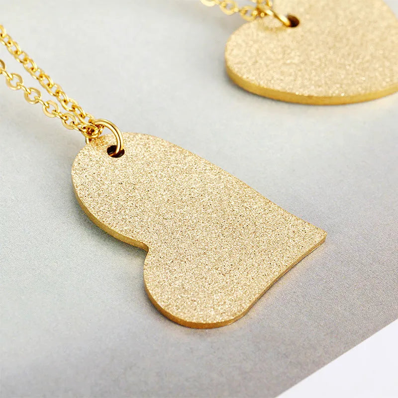 Close-up of a women's geometric heart-shaped titanium steel pendant necklace on a chain.