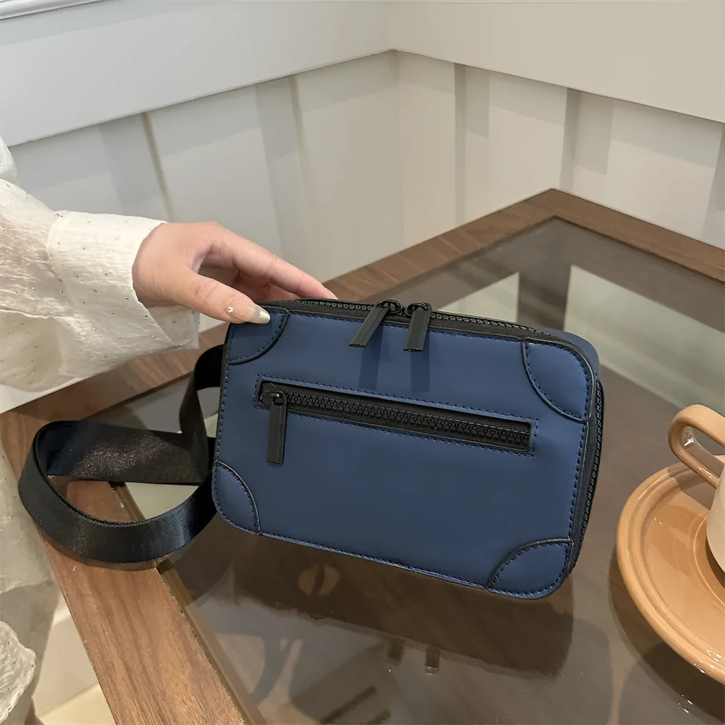 A dark grey women's square crossbody bag made of PU leather, shown with a single shoulder strap and visible sewing line detail.