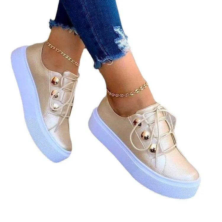 Women's white lace-up flats sneakers with decorative rivet detailing on casual shoe