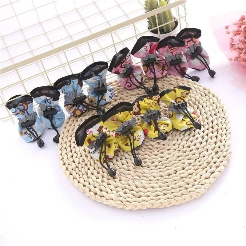 Set of four soft-soled cloth dog shoes for pets in assorted colours including red, blue, and black.