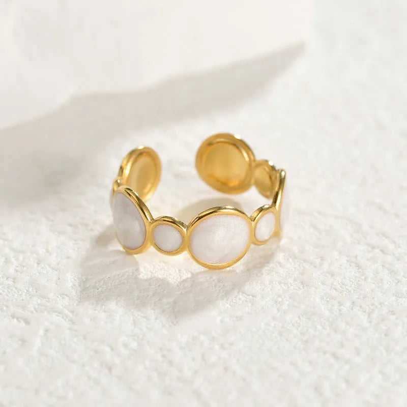 A geometric stainless steel ring with an adjustable opening on a plain background.