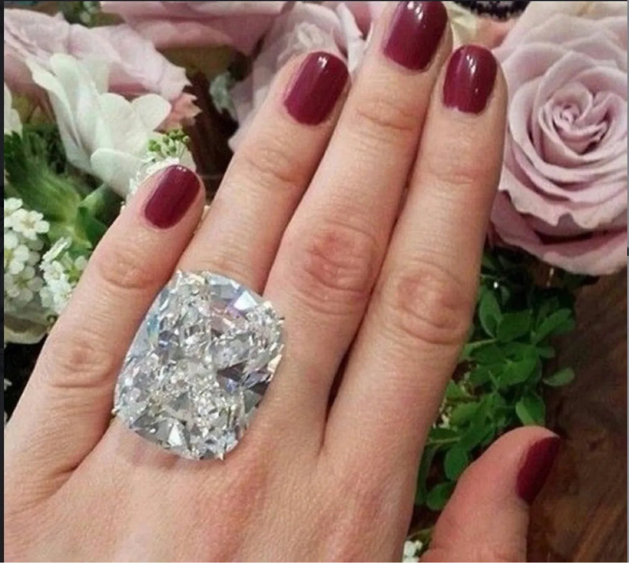 Simple white gold colour alloy ring with an inlaid square diamond, shown on a finger.