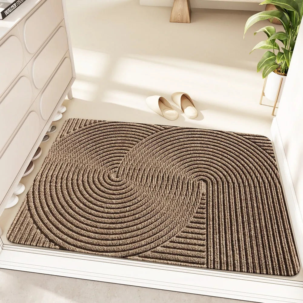 Green alien-shaped entrance mat with cartoon pattern on a wooden floor.