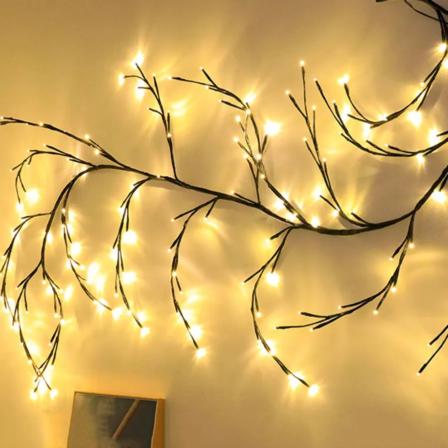 Flexible plastic willow vine LED garland light with warm white lights, shaped on a wall.