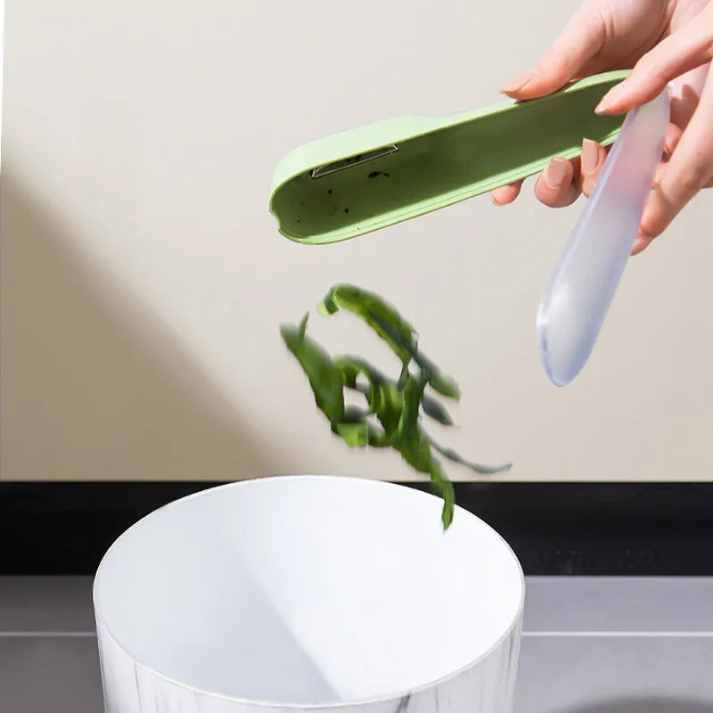 Dark green kitchen peeler with storage tube, showing stainless steel blade and non-slip handle.