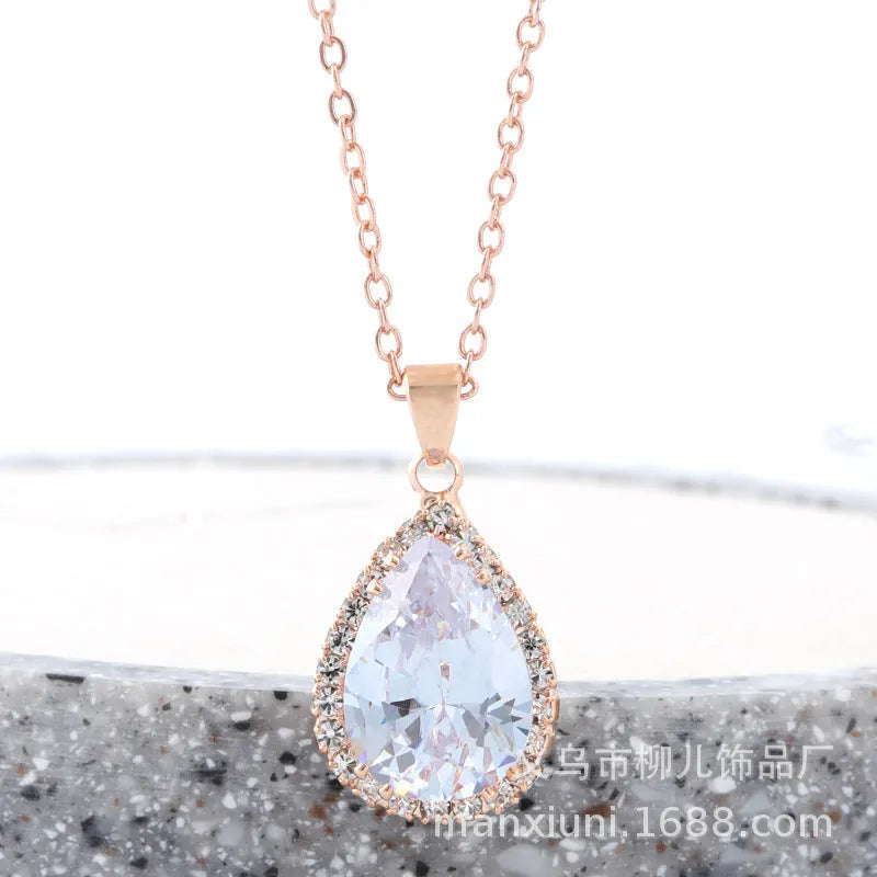 Close-up of a women's pink rose gold drop necklace with geometric rhinestone patterns on an alloy setting.