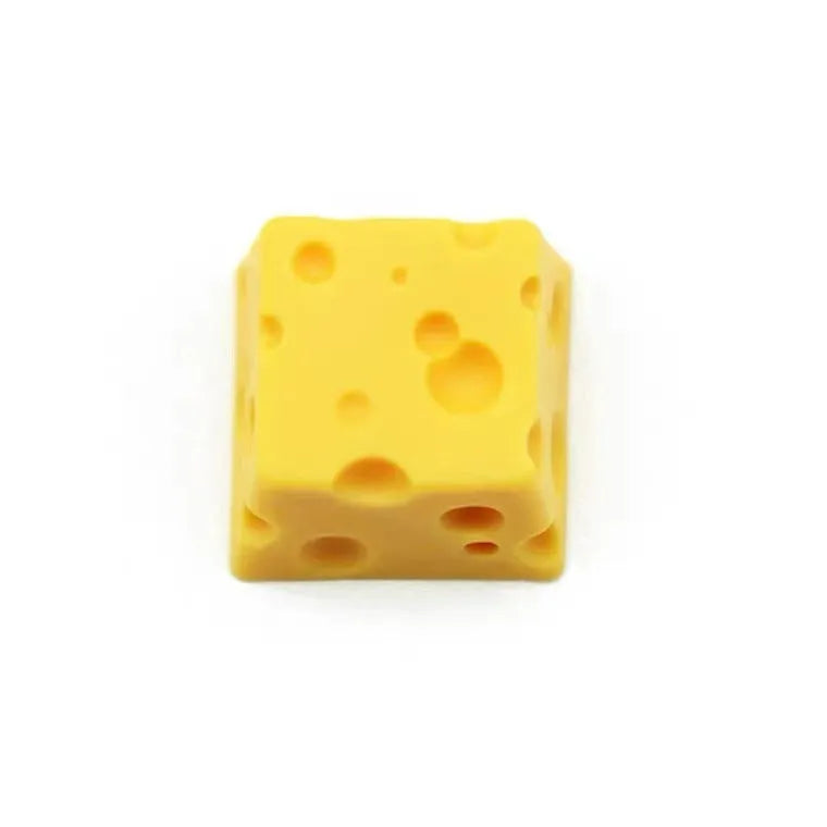 Close-up of a yellow resin cheese-shaped keycap for a mechanical keyboard.
