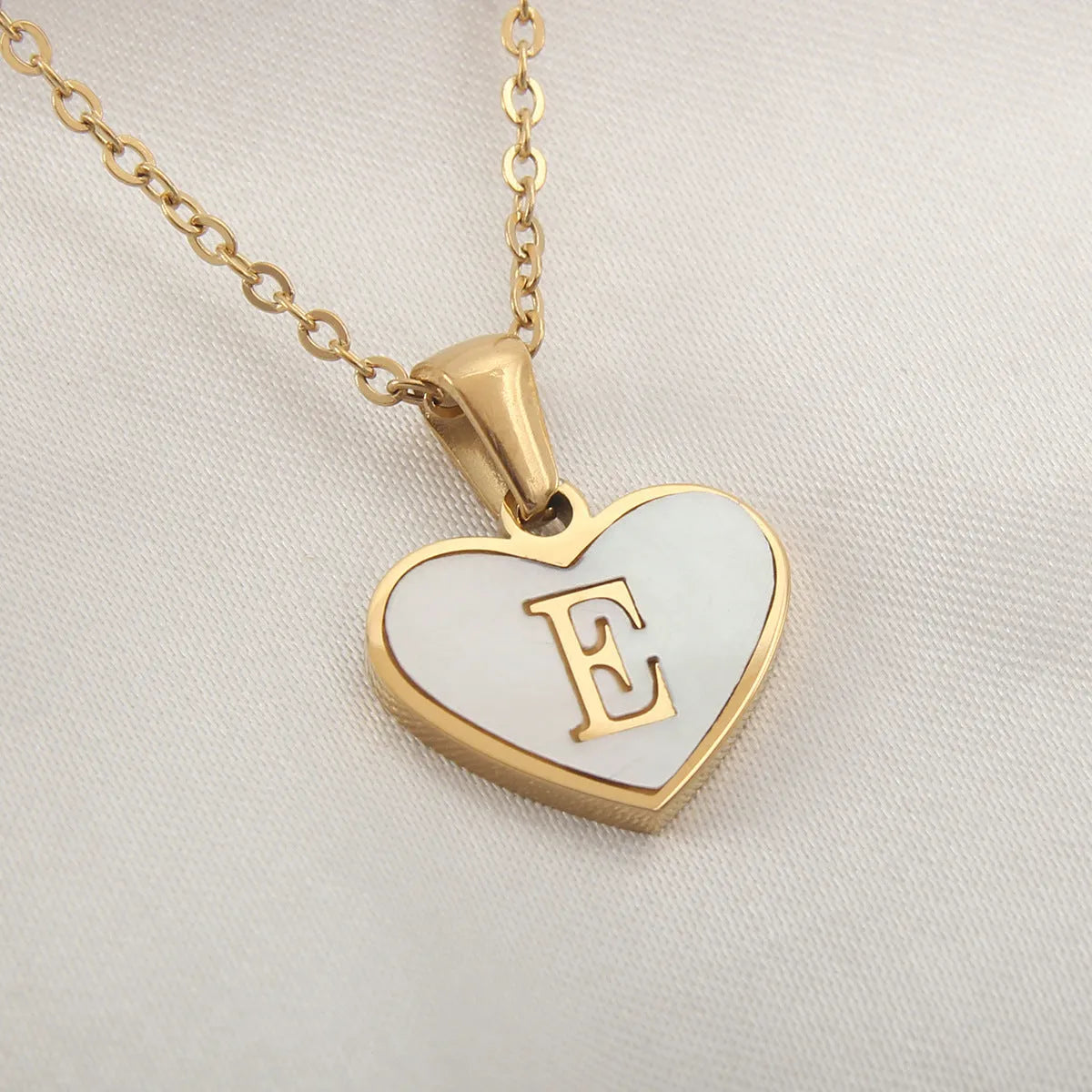 Gold plated chain necklace with a white shell heart-shaped pendant personalised with a single letter initial.