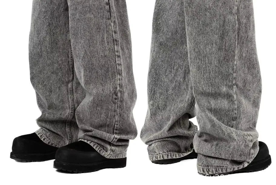 Grey loose straight-leg denim trousers for men and women laid flat, showing mid waist and classic cut.