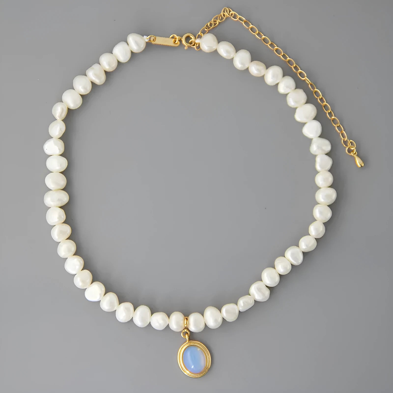 Round geometric sterling silver necklace with an irregular white pearl pendant on a chain.