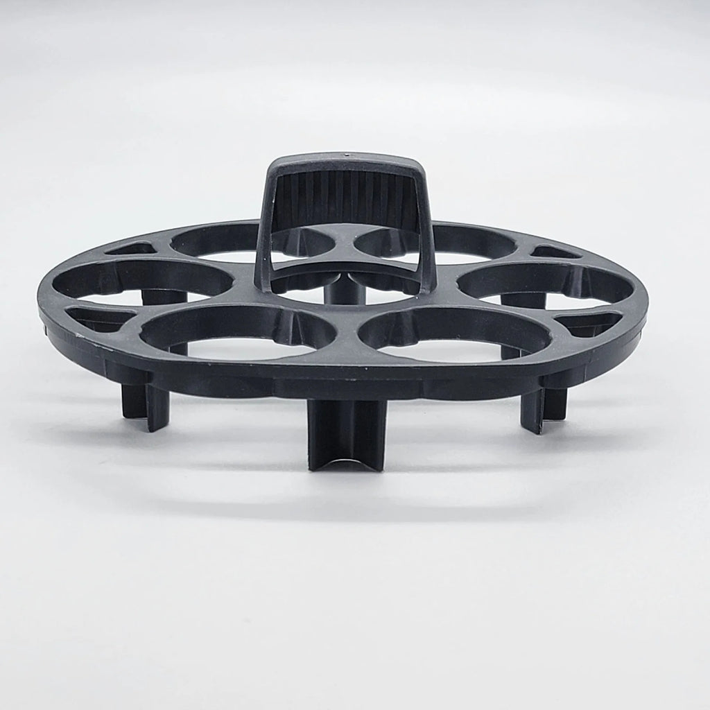 Black plastic egg holder rack for a cooking machine on a kitchen countertop.