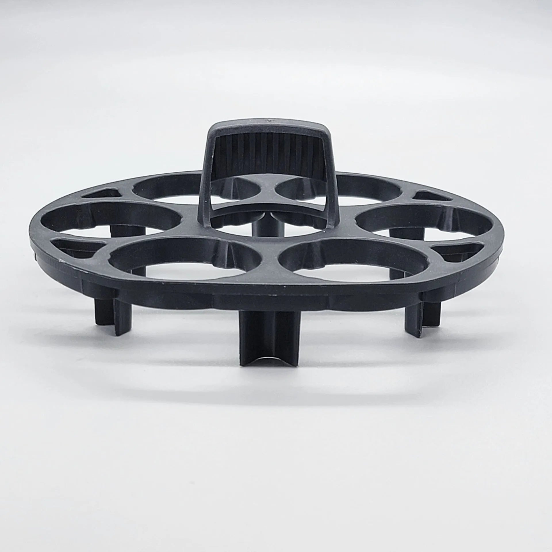 Black plastic egg holder rack for a cooking machine on a kitchen countertop.