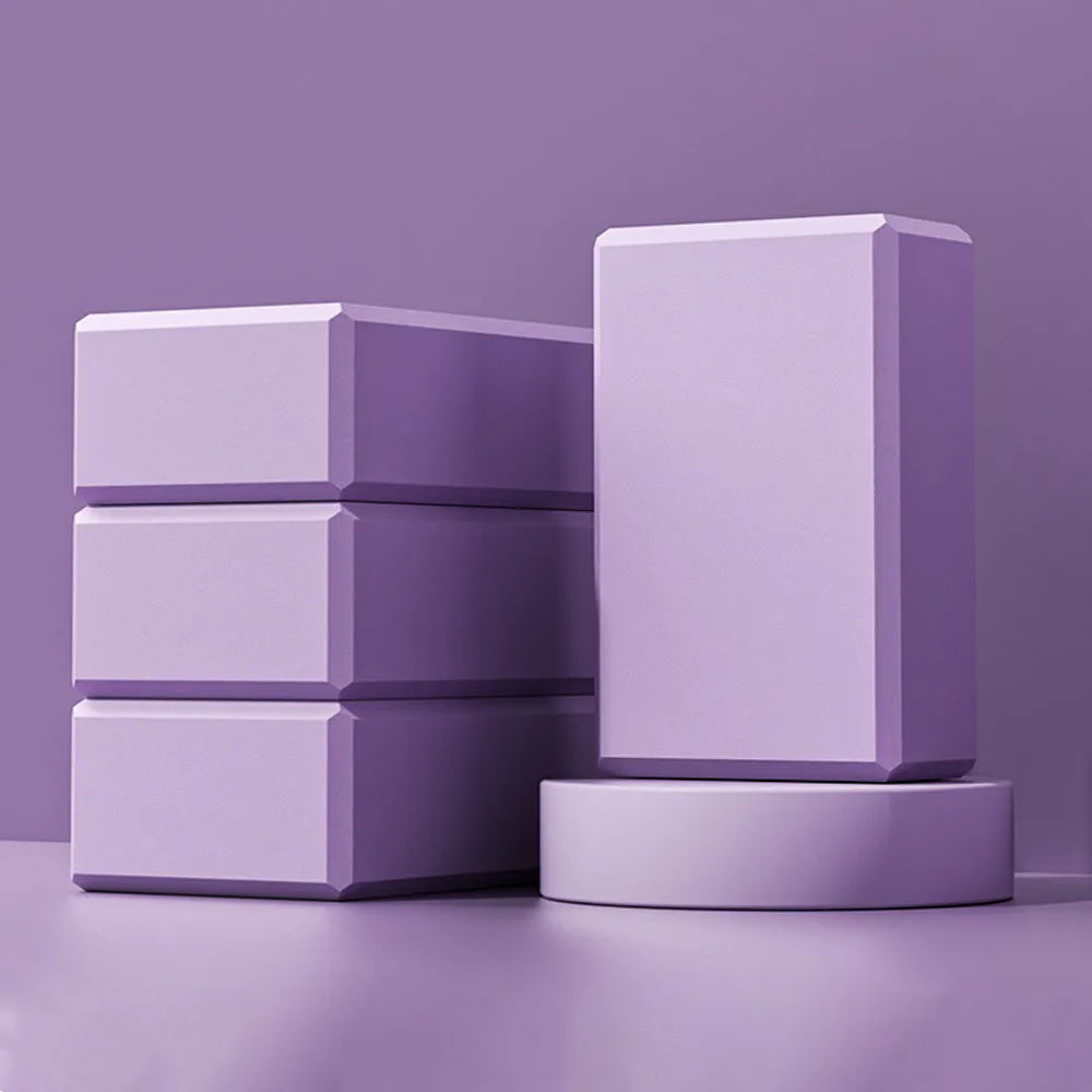Solid colour EVA foam yoga block on a gym mat, showing its rectangular shape and ridged sides.