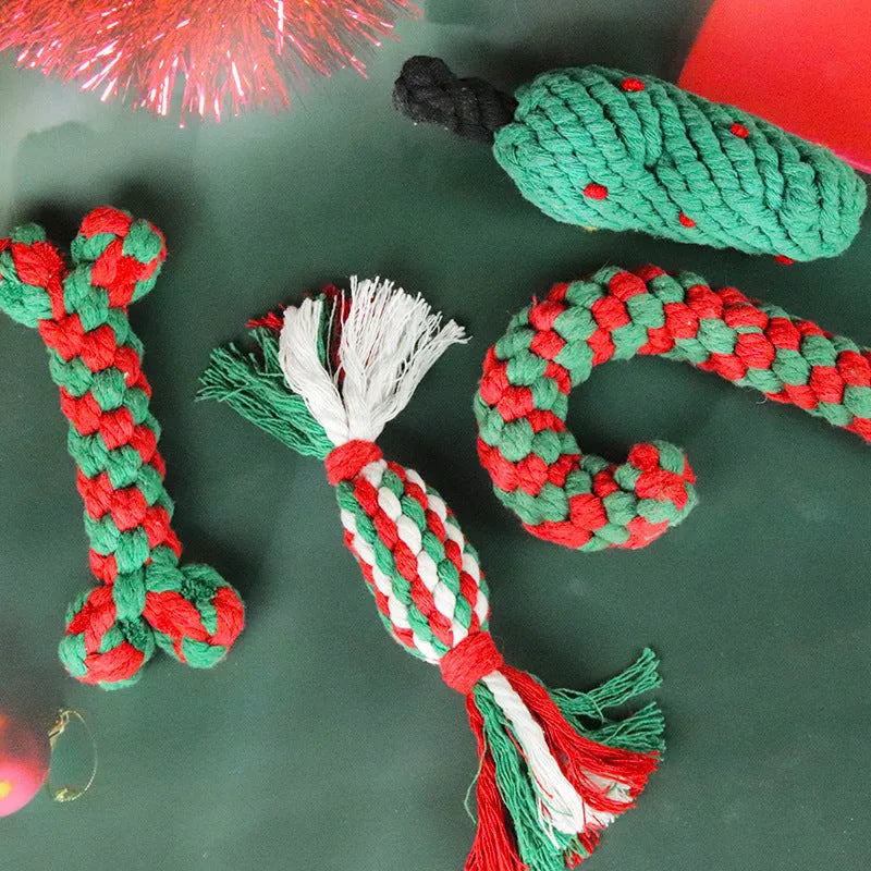 Four Christmas-themed cotton rope dog toys in red and green, including candy cane, bone, crutch, and tree shapes