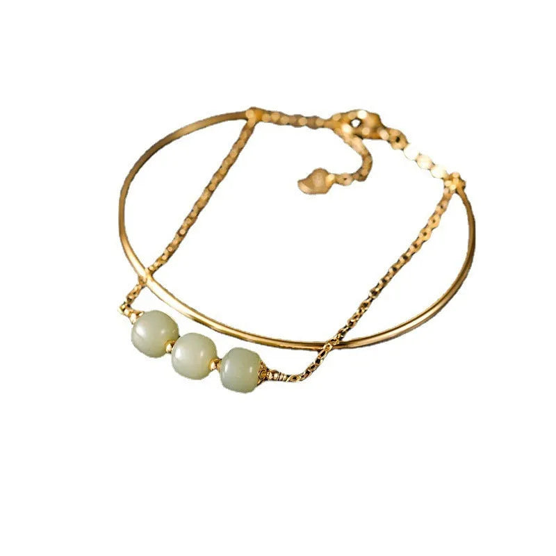 Hetian jade bracelet with gold inlay in single, double, and three bead versions on a wrist.