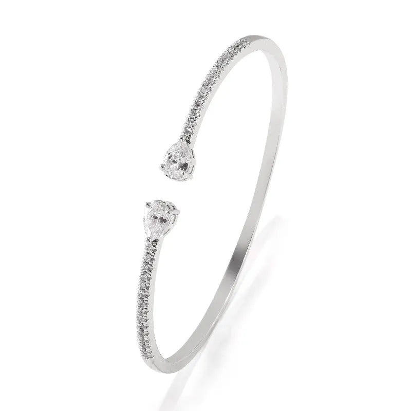 Adjustable copper bracelet with inlaid white zircon stones on a wrist.
