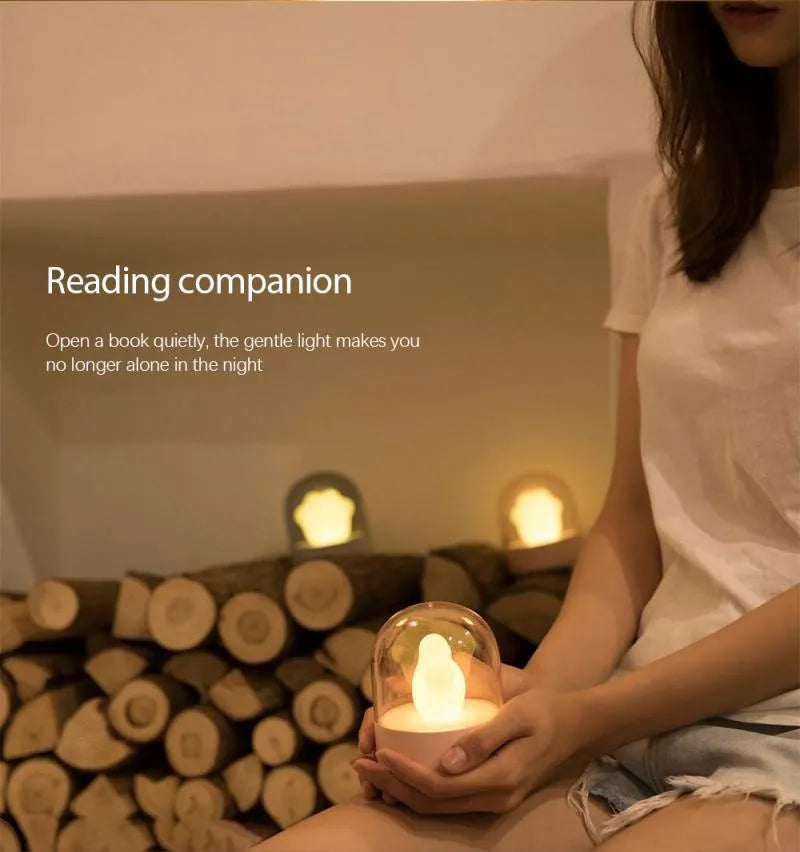 Grey cat paw shaped USB rechargeable night light with music box function on wooden desktop