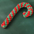 Four Christmas-themed cotton rope dog toys in red and green, including candy cane, bone, crutch, and tree shapes