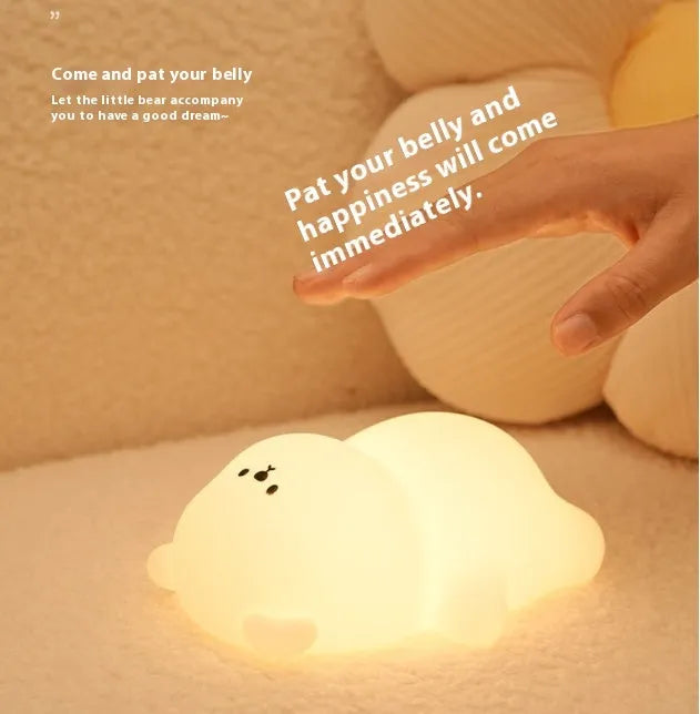 Lying flat bear silicone small night lamp with three-gear dimming and RGB colour switching on a bedside table
