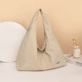 Soft heart-shaped nylon underarm bag for women in yellow, shown worn crossbody.