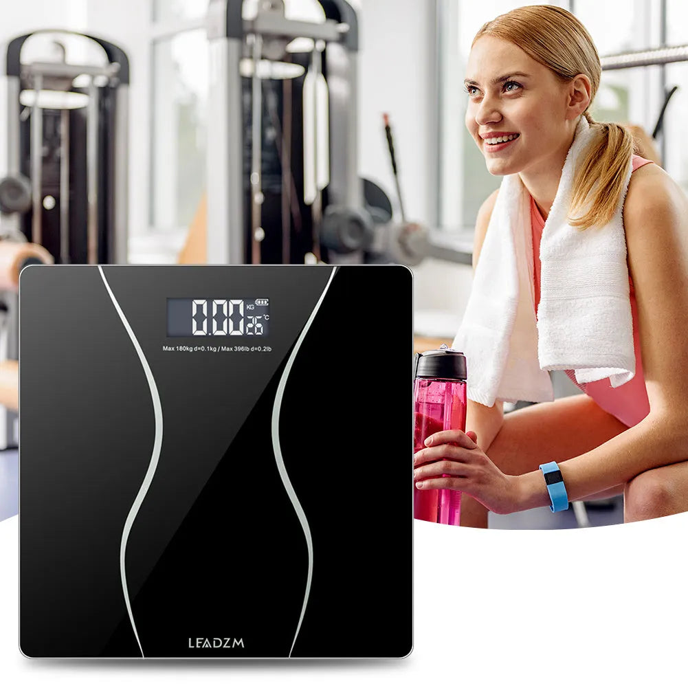 Black electronic bathroom scale on a flat surface showing digital display.