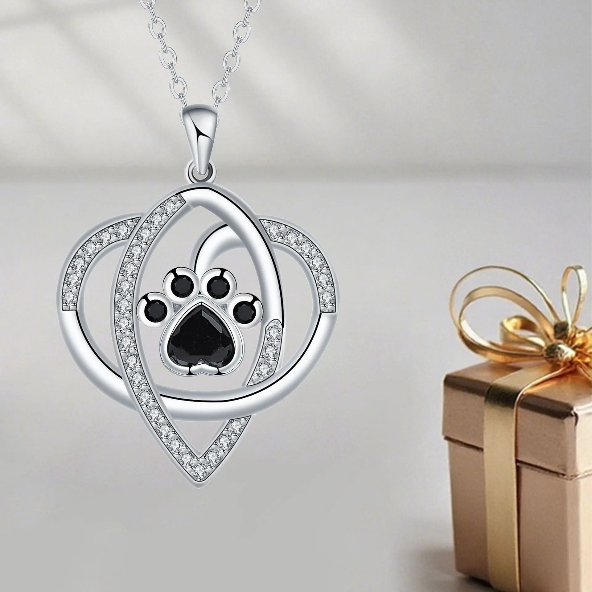 Close-up of dog and cat paw print pendant necklace with cross chain