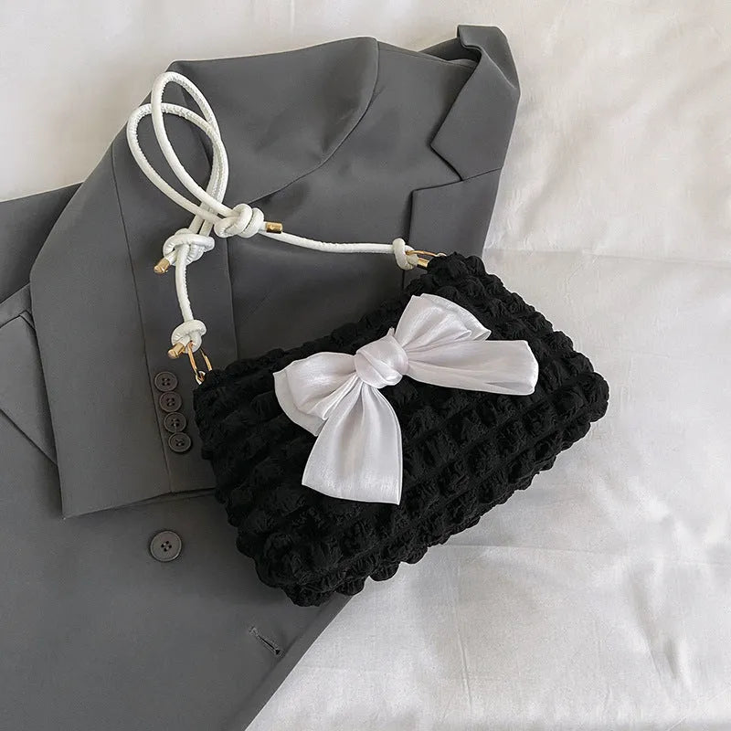 Women's black canvas one-shoulder handbag with a single strap and visible sewing thread detail