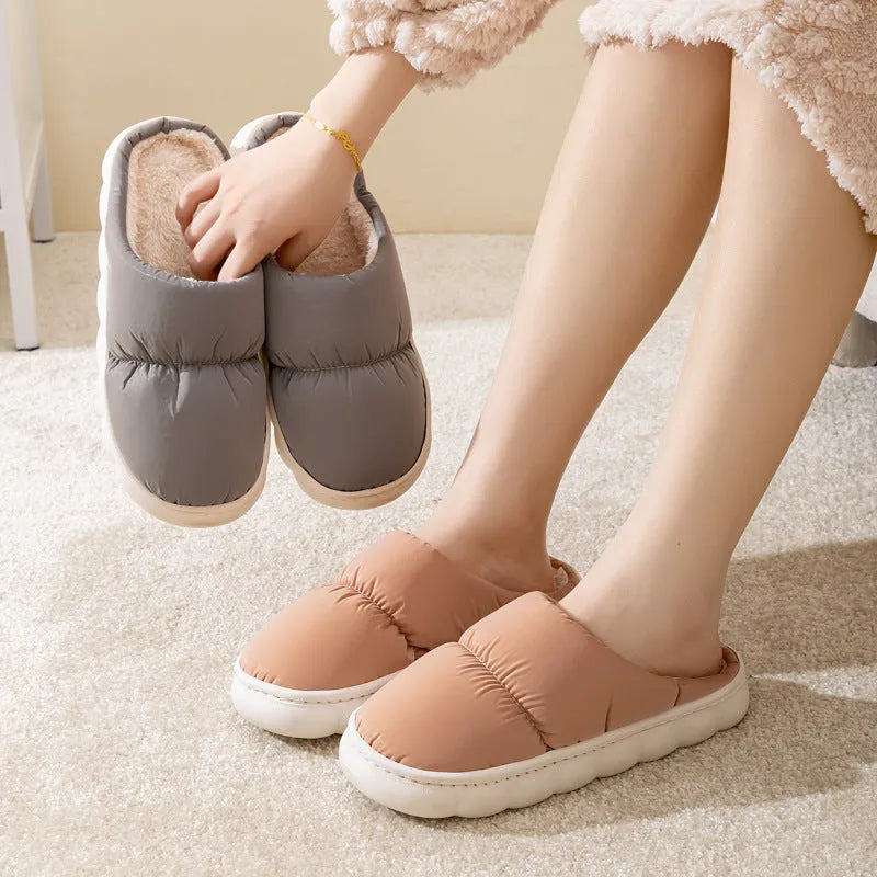 A pair of thick-soled indoor slippers with an artificial leather upper and soft plush lining, shown in a choice of colours.