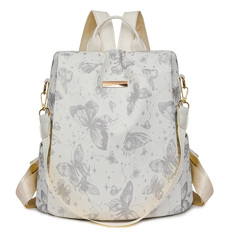Butterfly print PU leather backpack in purple shown from the side, featuring sewing line details and shoulder straps.