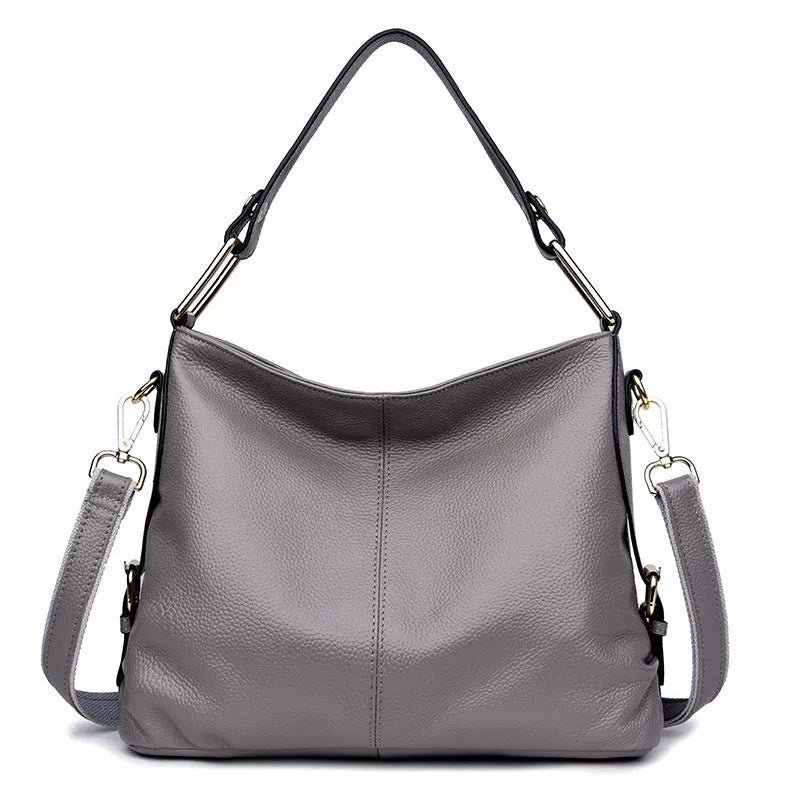 Genuine leather vertical square crossbody bag in black colour with visible stitching and multiple compartments.