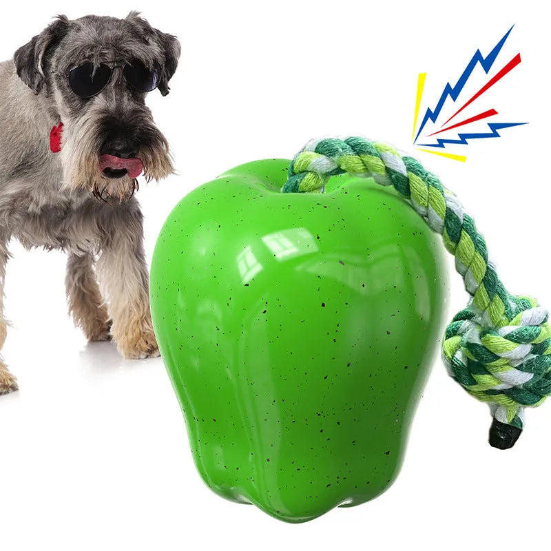 Green apple-shaped dog molar toy with dropping ball mechanism on white background