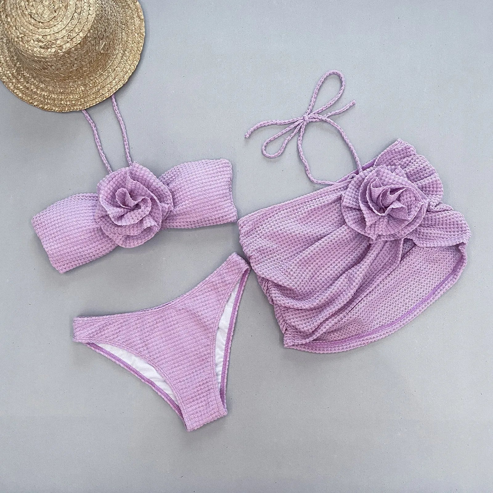 Women's white three-piece bikini swimsuit with 3D flower split detail on mannequin