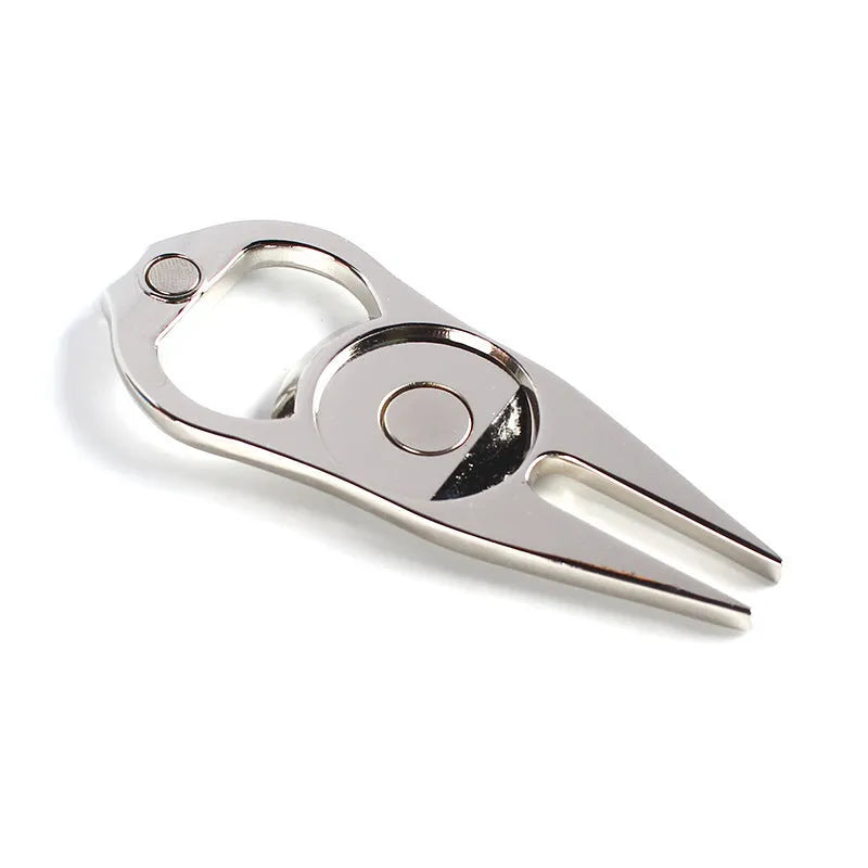 Black zinc alloy golf ball yoke and bottle opener tool on a putting green.