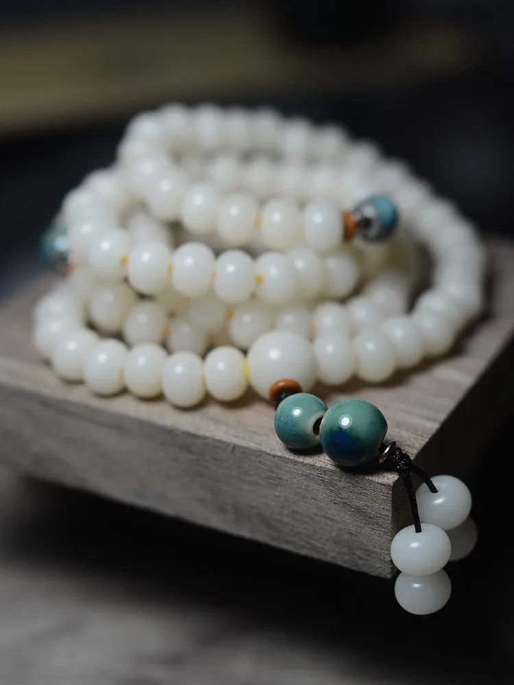 White Jade Bodhi Root Oblate Bead Bracelet with 108 flat round beads on a wrist.