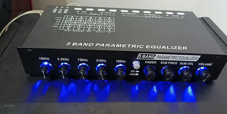 Car audio equaliser with front panel controls showing frequency bands and volume adjustments