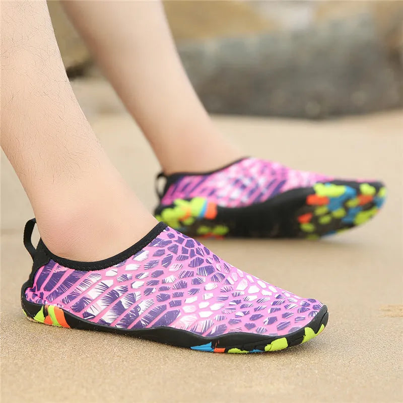 Blue and camouflage Lycra beach wading shoes with EVA midsoles on a sandy background