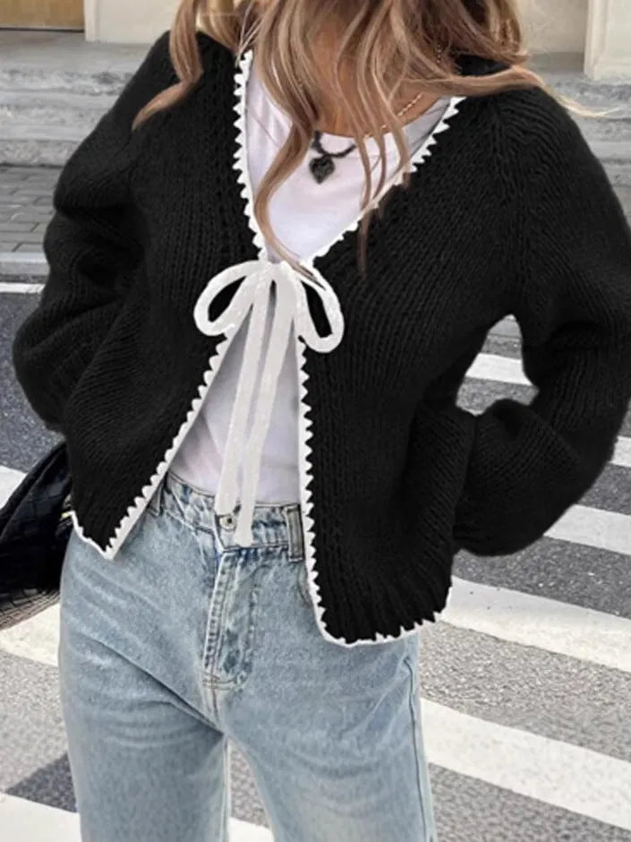 Grey lace-up sweater cardigan with long sleeves and crocheted flower decoration on the front.
