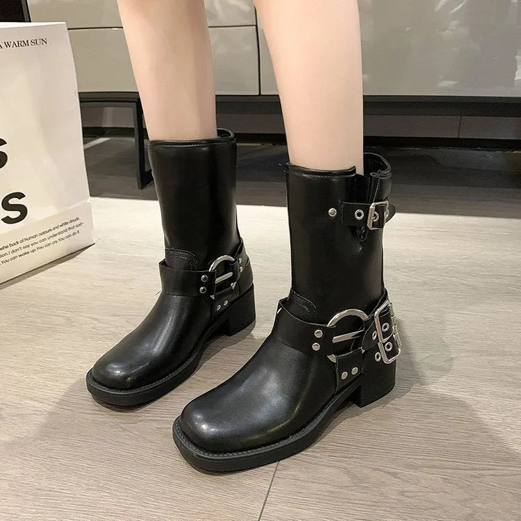 Women's black platform boots with belt buckle detail showing middle calf length