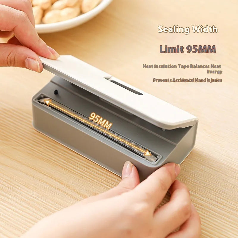 Small white handheld heat sealing machine for plastic food bags on a kitchen worktop.