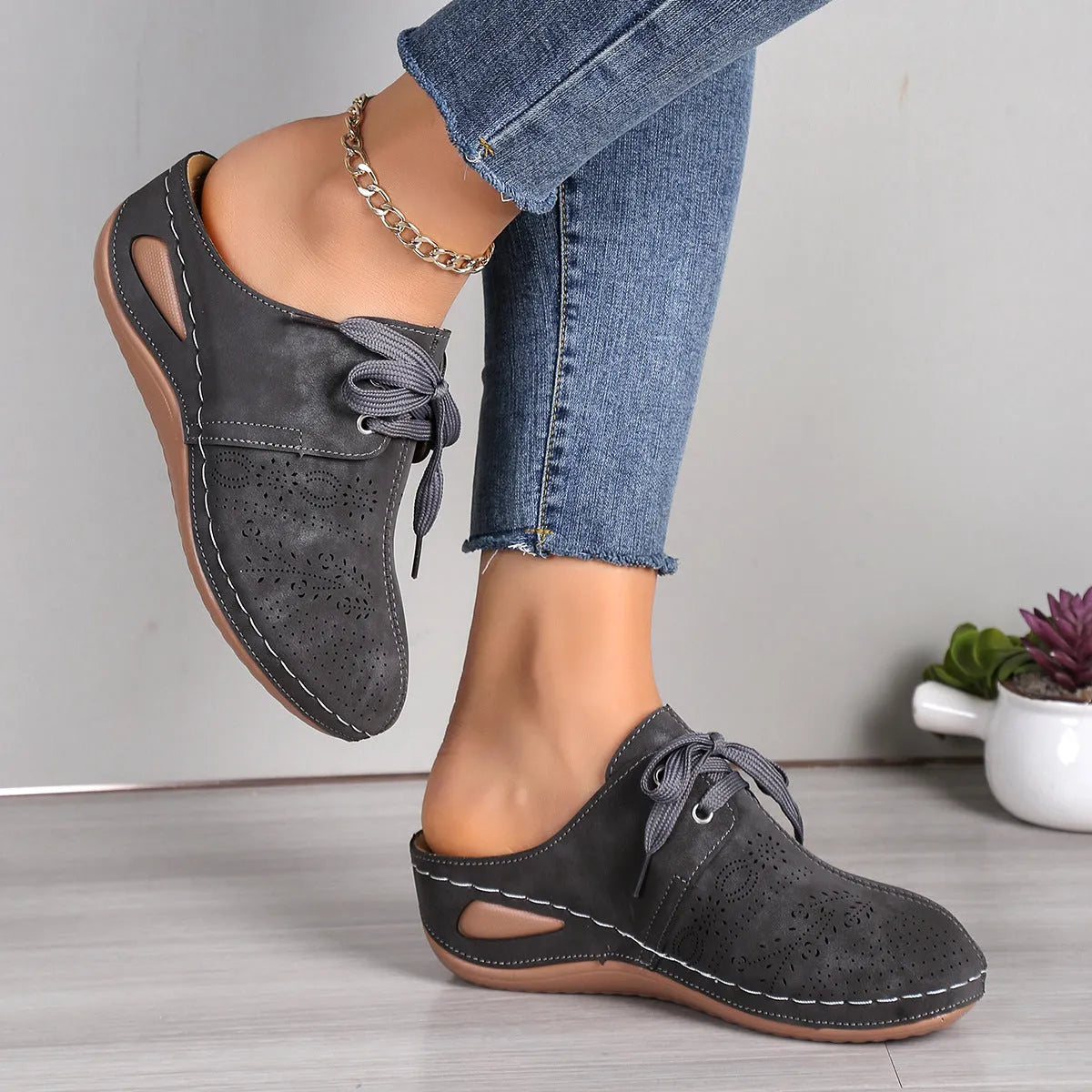 Women's black lace-up wedge slippers with a suede upper and rubber sole on a white background.