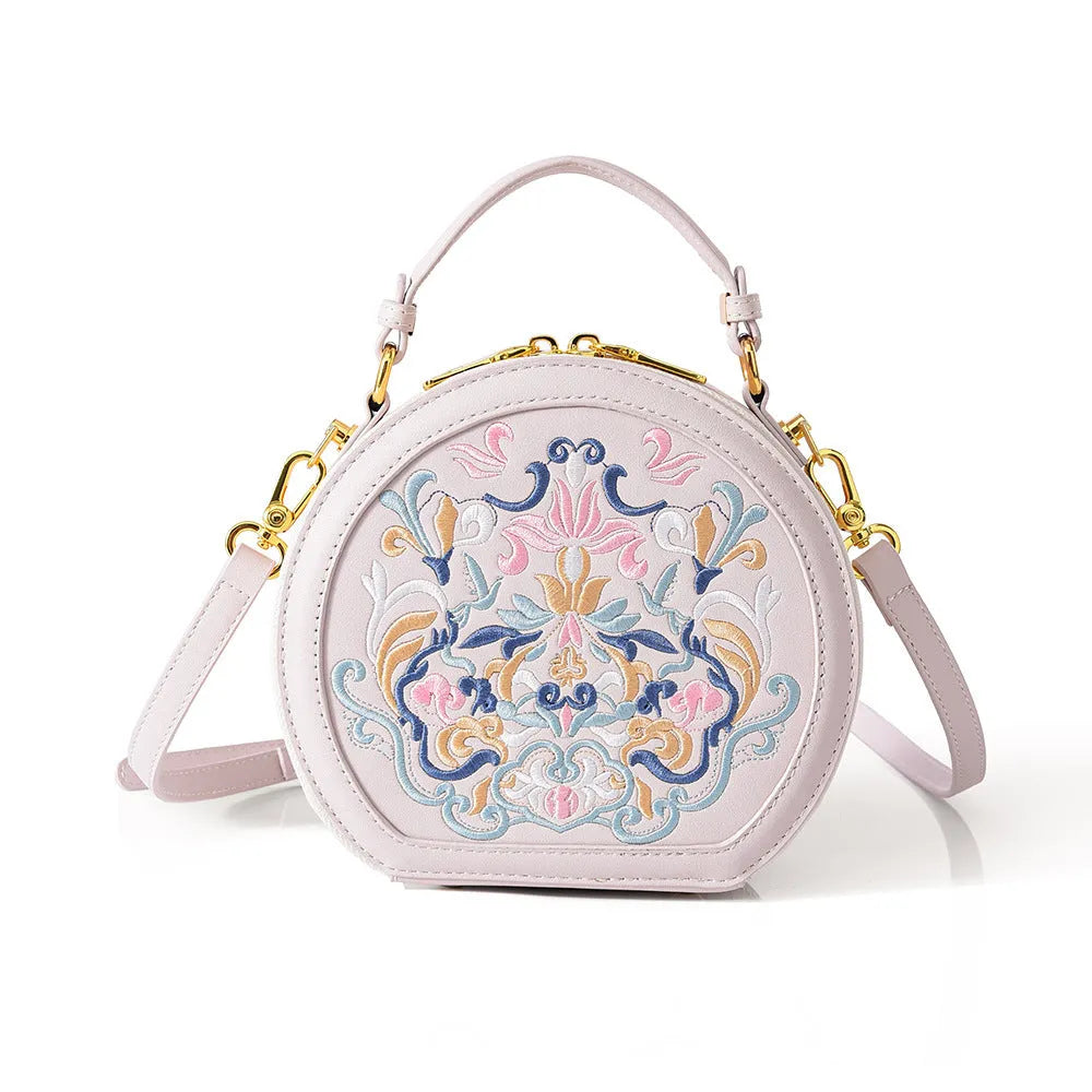 National style round crossbody bag in khaki PU leather with embroidery and sewing line details, shown on a plain background