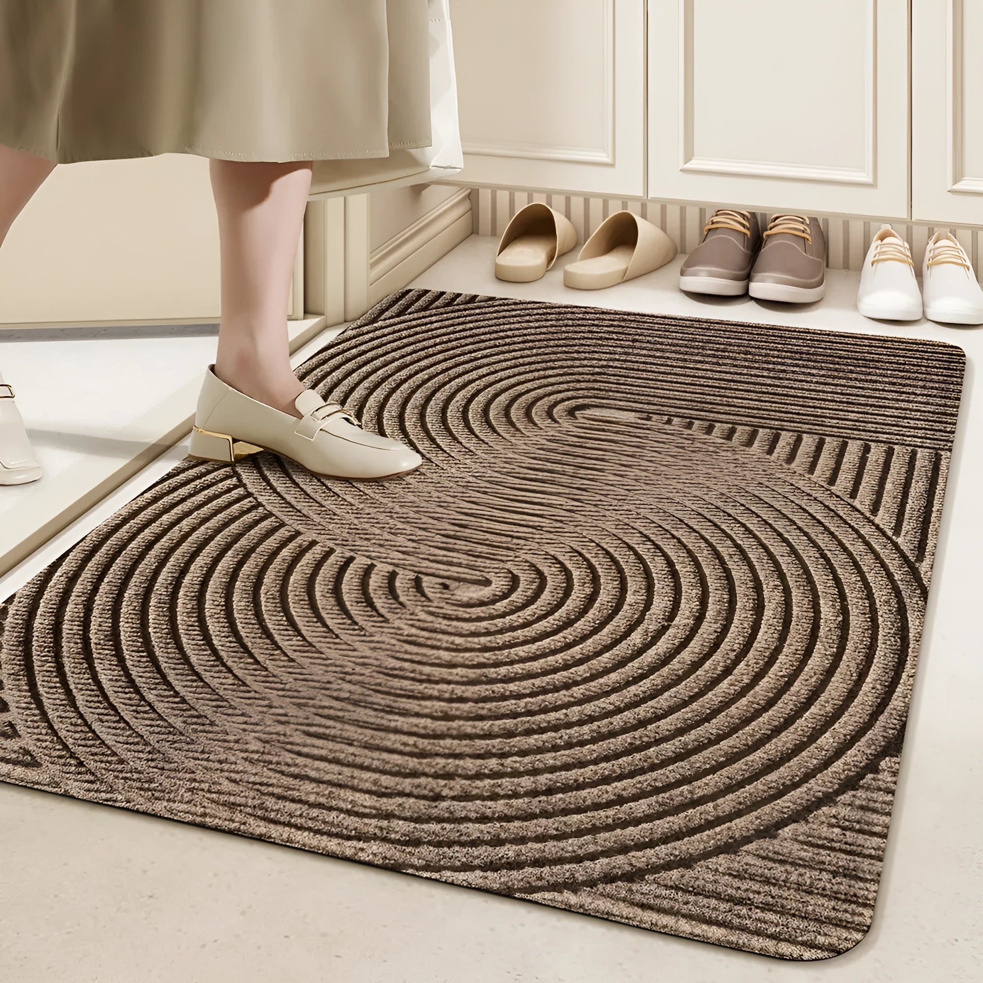 Green alien-shaped entrance mat with cartoon pattern on a wooden floor.