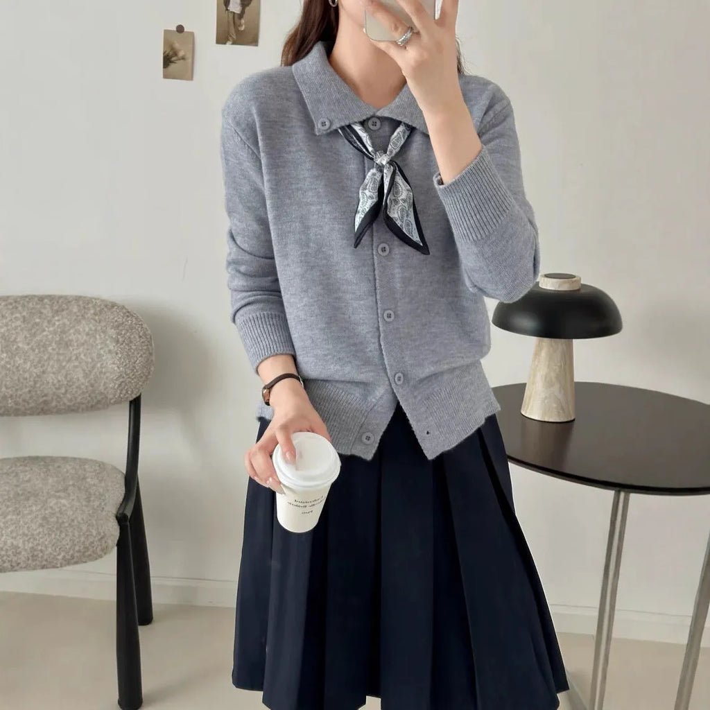 Beige lapel scarf cardigan sweater with long sleeves and splicing detail on a hanger.
