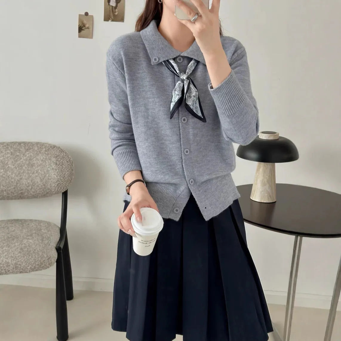 Beige lapel scarf cardigan sweater with long sleeves and splicing detail on a hanger.