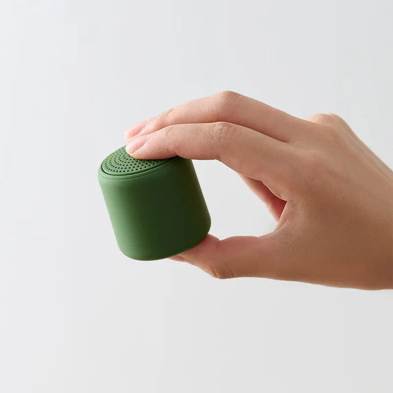 Mini portable wireless Bluetooth speaker in black with rounded edges and fabric grille, 45x48mm size
