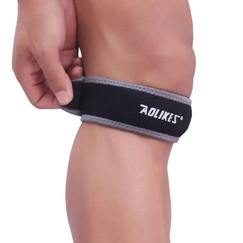 Black and grey patella retinaculum knee support strap for adult sports use.